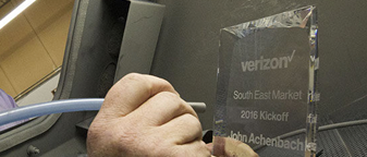 Glass award being etched with corporate branding